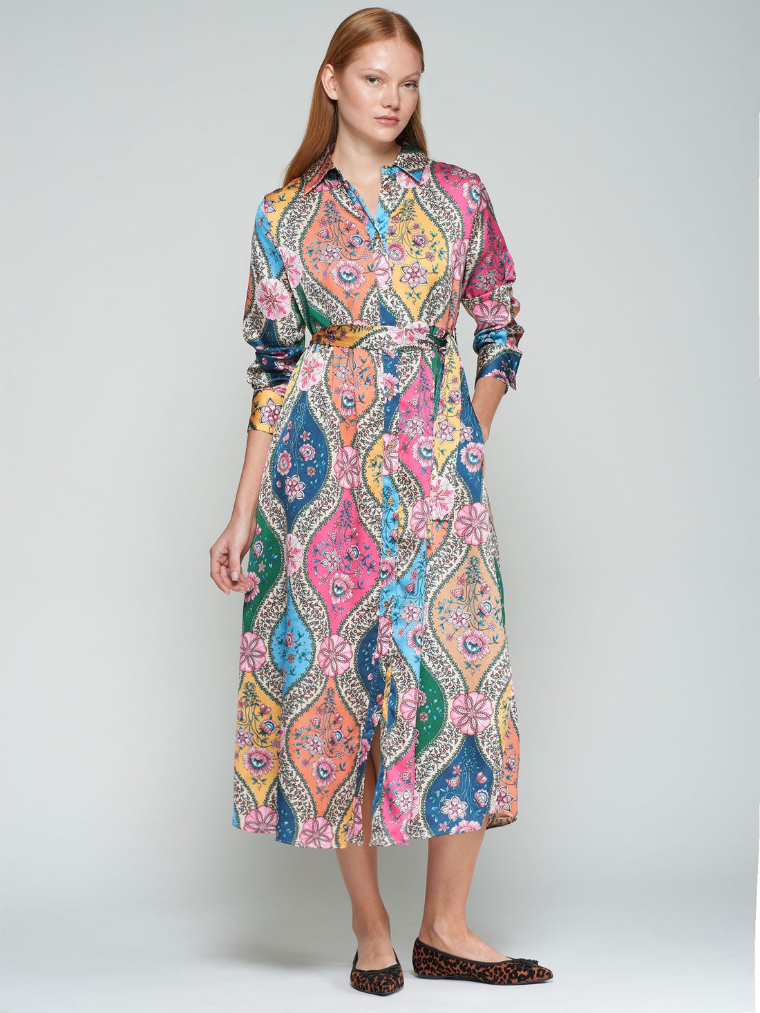 Woman wearing a colorful patterned dress on a white background